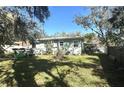 View of the home's backyard, featuring a lawn and the rear exterior of the house at 1506 Palmetto St, New Smyrna Beach, FL 32168