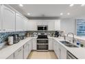 Modern kitchen with white cabinets, quartz countertops, and stainless steel appliances at 1705 S Atlantic Ave # 302, New Smyrna Beach, FL 32169