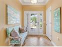 Bright and airy entryway with a bench and coastal decor at 1938 Turnbull Lakes Dr, New Smyrna Beach, FL 32168