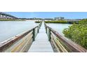 Wooden walkway leads to a pier over the calm water at 2 Richmond Dr, New Smyrna Beach, FL 32169