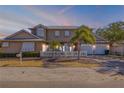 Beautiful two-story home featuring a three-car garage, lush landscaping, and a white picket fence at 201 S Cooper St, New Smyrna Beach, FL 32169