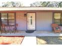 Quaint front porch with seating area and landscaping at 2309 Lime Tree Dr, Edgewater, FL 32141