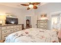 Bright bedroom featuring a dresser, TV, and access to bathroom at 2717 Needle Palm Dr, Edgewater, FL 32141