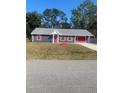 Newly painted home with gray siding, red accents, and a large yard at 2723 Juniper Dr, Edgewater, FL 32141