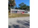 Charming one-story home with gray siding and red accents at 2723 Juniper Dr, Edgewater, FL 32141