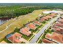 Aerial view of home with screened-in pool, tile roof, and golf course view at 2824 S Asciano Ct, New Smyrna Beach, FL 32168