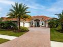 Elegant single-story home boasting a three-car garage, brick-paved driveway, and mature landscaping at 2824 S Asciano Ct, New Smyrna Beach, FL 32168