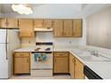 Light wood cabinets, white appliances, and kitchen sink at 2916 Duchess Oak Ct, St Cloud, FL 34769