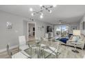 Bright dining area with glass table and chairs, open to living room and ocean view at 3001 S Atlantic Ave # 501, New Smyrna Beach, FL 32169