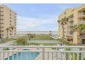 Balcony view of ocean, beach, and adjacent building at 423 S Atlantic Ave # 101, New Smyrna Beach, FL 32169