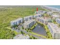 An aerial view of beachfront condos with a serene pond and lush surroundings at 5300 S Atlantic Ave # 5-206, New Smyrna Beach, FL 32169