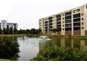 Building beside a pond with a water fountain, showcasing landscaping and serene atmosphere at 5300 S Atlantic Ave # 8-302, New Smyrna Beach, FL 32169