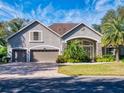 Two-story house with a three-car garage and manicured lawn at 720 Stonewood Ct, New Smyrna Beach, FL 32168