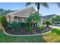 Landscaped front yard with palm trees and manicured lawn at 1763 Weeping Elm Cir, Port Orange, FL 32128