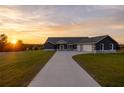 Single-story home with gray siding, stone accents, and a three-car garage at 18459 Sw 66Th Loop, Dunnellon, FL 34432