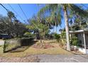 Landscaped front yard with a hedge and mature trees in front of the house at 1975 Lake Dr, New Smyrna Beach, FL 32168