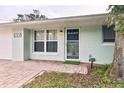 Light green house with a dark front door and brick walkway at 2307 Saxon Dr, New Smyrna Beach, FL 32169