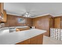 L-shaped kitchen with wood cabinets and white countertops at 2515 Fairfax Ave, New Smyrna Beach, FL 32168