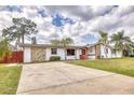 Inviting single-story home featuring a large driveway, stone details, and a lush, green yard at 2712 Queen Palm Dr, Edgewater, FL 32141