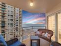 Relaxing balcony with ocean view, wicker furniture, and sunset at 2967 S Atlantic Ave # 801, Daytona Beach Shores, FL 32118