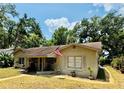 Well-kept ranch style home featuring an American flag and mature landscaping at 314 Hillman St, New Smyrna Beach, FL 32168