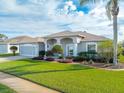 Charming one-story home featuring a well-manicured lawn and tasteful landscaping, enhancing its curb appeal at 323 Mariners Gate Dr, Edgewater, FL 32141