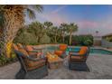 Relaxing patio with fire pit and wicker chairs near the pool at 4611 Doris Dr, New Smyrna Beach, FL 32169