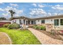 Inviting single-story home showcasing a brick pathway, stone accents, and a well-kept lawn at 4650 Saxon Dr, New Smyrna Beach, FL 32169