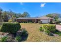 Brick ranch home with a well-manicured lawn and mature landscaping at 51 Club House Blvd, New Smyrna Beach, FL 32168