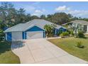 Blue house with metal roof, three-car garage, and landscaped yard at 610 Renner Rd, Port Orange, FL 32127
