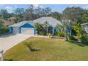 Blue house with metal roof, three-car garage, and landscaped yard at 610 Renner Rd, Port Orange, FL 32127