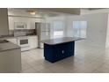 Spacious kitchen with white cabinets, white appliances, and large center island at 621 Middlebury Loop, New Smyrna Beach, FL 32168