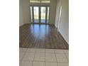 Bright living room featuring wood floors and glass doors leading to the backyard at 621 Middlebury Loop, New Smyrna Beach, FL 32168