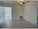 Open-concept living room featuring tiled floors and a ceiling fan at 621 Middlebury Loop, New Smyrna Beach, FL 32168