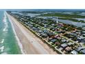 Aerial view showing home's location near beach and lagoon access at 6345 River Rd, New Smyrna Beach, FL 32169