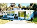 Renovated light blue home with a large window, welcoming porch and lush landscaping at 69 E Bayshore Dr, Port Orange, FL 32127