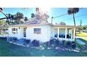 Light blue house with a screened porch, mature landscaping and a sunny outdoor space at 69 E Bayshore Dr, Port Orange, FL 32127