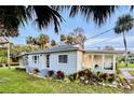Quaint light blue home with a screened porch, and nicely landscaped yard at 69 E Bayshore Dr, Port Orange, FL 32127