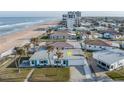 Aerial view of a quaint beach cottage with a one-car garage surrounded by palm trees and other homes at 8 Ocean Dr, Ormond Beach, FL 32176