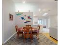 Open-concept dining area featuring wood floors, a colorful rug, and a view of the kitchen at 808 E 19Th Ave, New Smyrna Beach, FL 32169