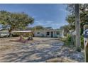 Charming home with gravel driveway and garden bed featuring colorful potted plants at 817 E 12Th Ave, New Smyrna Beach, FL 32169