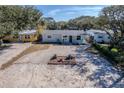 Charming home featuring a gravel driveway and inviting front porch with cheerful blue seating at 817 E 12Th Ave, New Smyrna Beach, FL 32169