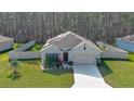 An elevated view of a well-maintained single-story home with solar panels, a two-car garage, and a fenced yard at 114 Sunset Point Dr, Ormond Beach, FL 32174