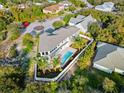 Aerial view of luxurious home featuring a well-manicured yard, pool, and beautiful neighborhood at 13 Arena Blanca, Ponce Inlet, FL 32127