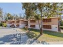 Condo building with parking lot and sidewalk, showcasing the exterior and surrounding greenery at 150 Wax Myrtle Woods Ct # 7B, Deltona, FL 32725