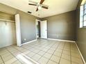 Bright bedroom featuring neutral walls, tile flooring, a ceiling fan, and closet at 1816 Fern Palm Dr, Edgewater, FL 32132