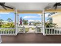 Covered porch with view of the neighborhood, ceiling fans, and stairs at 2815 Bay Side Dr, New Smyrna Beach, FL 32168