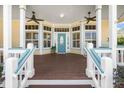 Beautiful front porch with ceiling fans and a decorative glass front door at 2815 Bay Side Dr, New Smyrna Beach, FL 32168