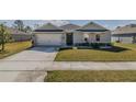 Exterior of a well-kept home with a two car garage, landscaping, and a driveway at 301 Sunset Point Dr, Ormond Beach, FL 32174