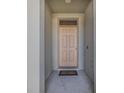 Front door entrance with neutral colored door, door mat, and porch overhang at 301 Sunset Point Dr, Ormond Beach, FL 32174